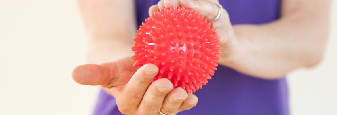 Zur Behandlung der Polyneuropathie macht Krebspatientin Übung mit Igelball.